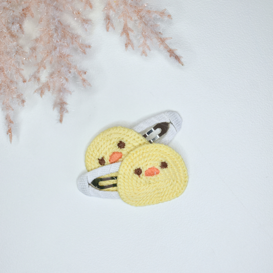 Two yellow crocheted chick hairclips for babies and toddlers.